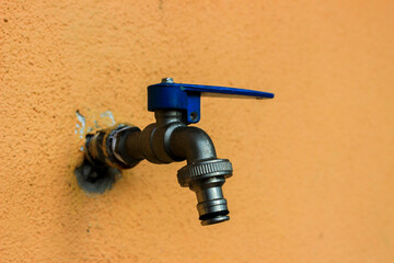 JOHOR, MALAYSIA - AUGUST 2, 2020: Water Faucet With Orange Wall Background