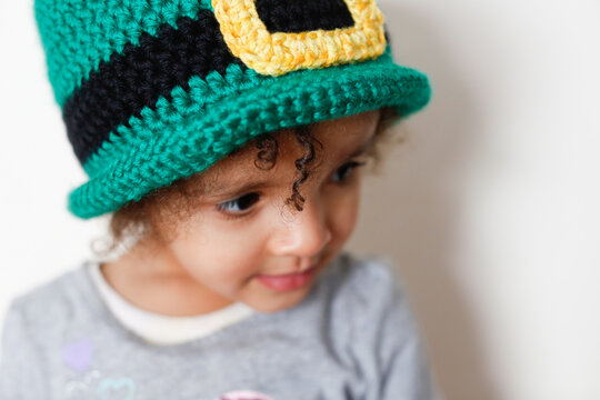Close up portrait of young girl wearing a handmade crochet leprechaun hat