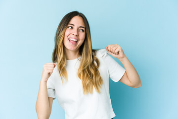 Fototapeta premium Young caucasian woman isolated on blue background dancing and having fun.