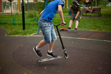 The child is riding a scooter on the street.