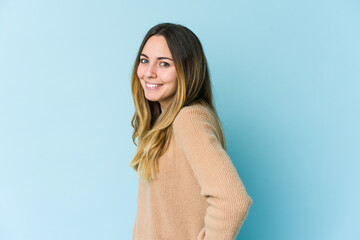 Fototapeta premium Young caucasian woman isolated on blue background confident keeping hands on hips.