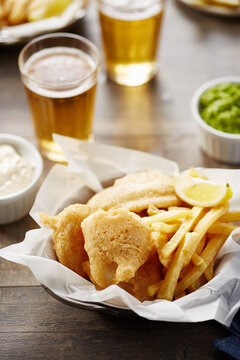 Beer glasses, snack and sauces on table