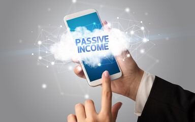 Female hand touching smartphone with PASSIVE INCOME inscription, cloud business concept
