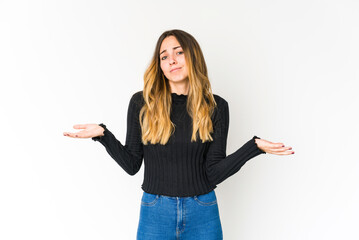Young caucasian woman isolated on white background doubting and shrugging shoulders in questioning...