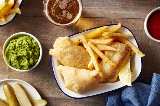 Fish and chips with sauces on wooden table