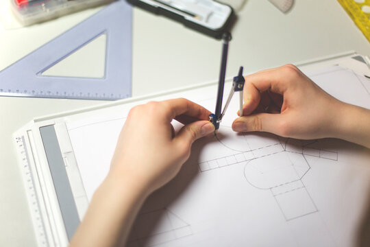 Hands using a compass for technical drawing...