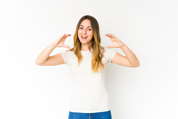 Fototapeta na wymiar Young caucasian woman isolated on white background holding something with palms, offering to camera.
