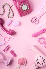 Creative layout made of hair dryer, scissors and accessories on pink background. Retro vintage 70's...