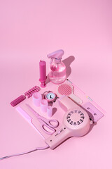 Vintage style layout with pink hairdryer, scissors, bottle, make up and cassette tape on pastel...