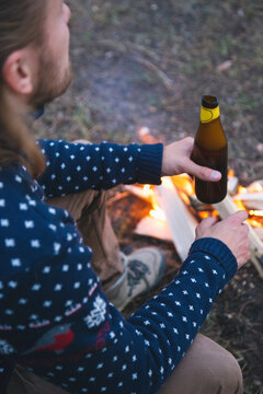 Bearded traveller holding bottle with cut neck