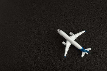 Toy plane on black background. Passenger transportation. Copy space