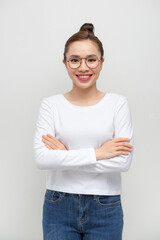Portrait of a happy woman standing with arms folded isolated on a white background