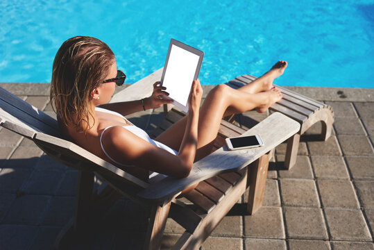 Modern lady with tablet on poolside