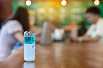 Alcohol nano mist sprayer for hand cleaning to prevent the spread of the Corona virus (Covid-19) to serve customers at coffee shop. Modern health technology. New normal lifestyle. Selective focus