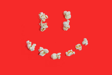 Popcorn funny smile. Happy banner. Top view. Red wallpaper close up
