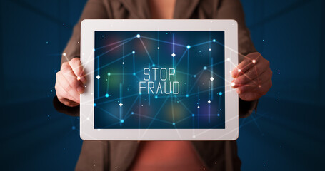 Young business person working on tablet and shows the digital sign: STOP FRAUD