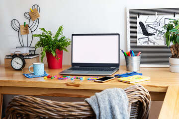 Design office desk with green plant and laptop with mock up in creative style. Workspace with white...