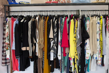 Variety of clothes hanging on rack in boutique, womens clothing