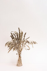 Dried flowers. Field dry spikelets and herbs in vases on a light pink background. Autumn concept