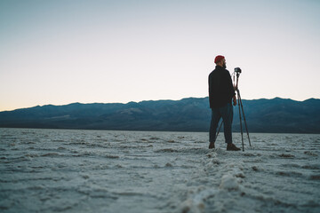 Anonymous male explorer shooting sunset in desert