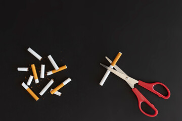 Overhead view broken cigarette with copy space and note , Stop smoking initiative concept of breaking cigarettes with workplace and pencil, Top view no smoke text with Scissor, World no tobacco day.