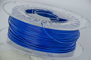 Plastic for 3D printing. Blue plastic filament, blue ABS/PLA coil for 3d printer on white background, isolated