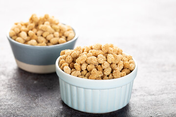 Dried white mulberry in bowl over stone background