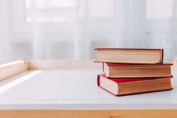 School supplies on whote table. Big red books on the table. Home study 2020.