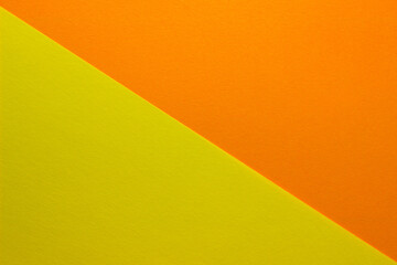 Background of yellow and orange paper divided diagonally. Sheets of blank orange and yellow paper with fine texture, close up.