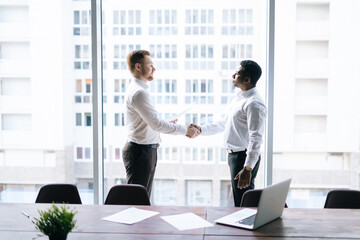 Side view of Caucasian businessman and African American businessman agreed contract and shaking...