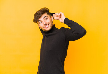 Young arabian man isolated on a yellow background stretching arms, relaxed position.