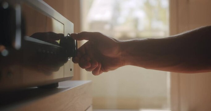 Adjusting the Hifi system and turning the volume up.