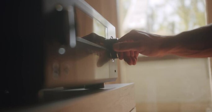 Adjusting the Hifi system and turning the volume up.
