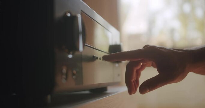 Adjusting the Hifi system and turning the volume up.
