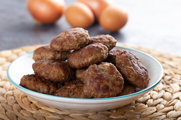 Minced meatball in bowl with eggs on the table. Homemade traditional Turkish meatballs.