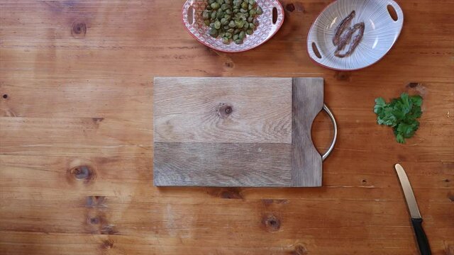White chef chopping food on wooden chopping board
