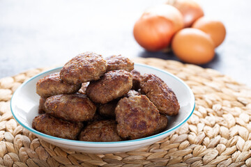 Minced meatball in bowl with eggs on the table. Homemade traditional Turkish meatballs.