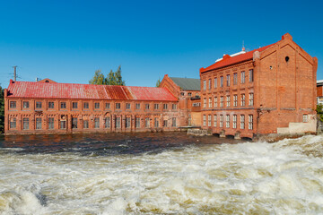 Kouvola, Finland - 15 September 2020: Old red brick buildings of Upm factory on rapids Kuusankoski.