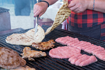 Traditional serbian street food (rostilj) - pljeskavica, cevapi, grilled chicken breast, bbq chicken wings and homemade sausages served with fresh bakery (lepinja)