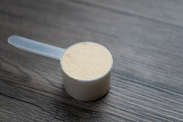 Whey protein powder with measuring Scoop, sports bodybuilding supplement.