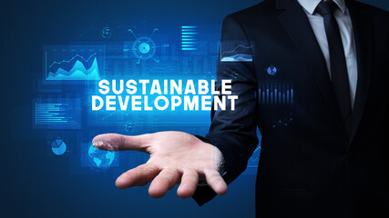 Hand of Businessman holding SUSTAINABLE DEVELOPMENT inscription, business success concept