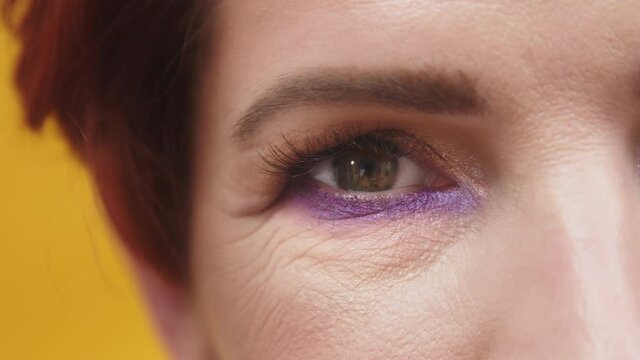 Adult Woman With Wrinkles Around Her Eye Wearing Beautiful Makeup. Girl Opening Her Eye And Looks At The Camera.  - Extreme Closeup Shot