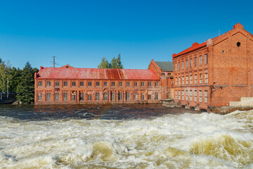 Kouvola, Finland - 15 September 2020: Old red brick buildings of Upm factory on rapids Kuusankoski.