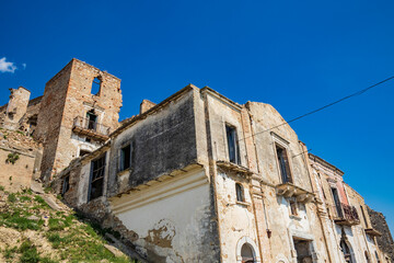 Craco, Matera, Basilicata, Italy. Ghost town destroyed and abandoned following a landslide. Collapsed houses and the remains invaded by vegetation. Broken walls, windows and doors, crumbling balconies