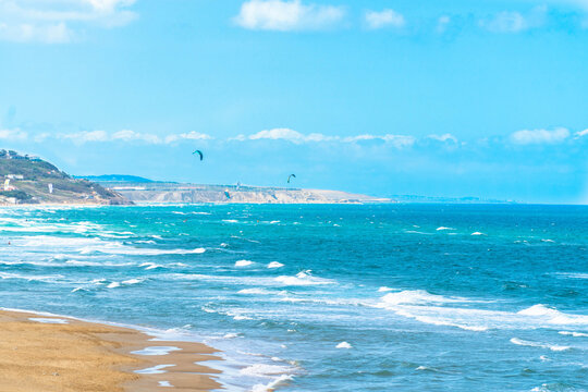 Wavy sea and blueish sky in Kilyos, peoples kitesurfing at the far end, Black Sea Region in Istanbul