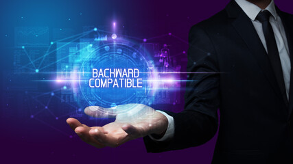 Man hand holding BACKWARD COMPATIBLE inscription, technology concept