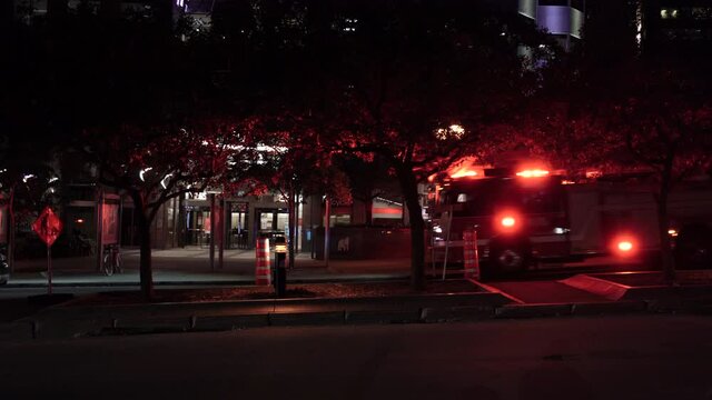 Firetrucks And A Car Passing By On The Street In Montreal, Quebec At Night - Coronavirus Pandemic In Canada - full shot