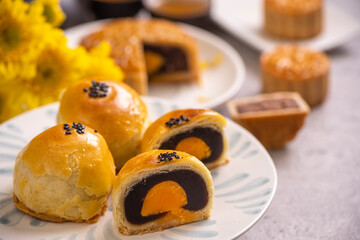 Tasty baked egg yolk pastry moon cake for Mid-Autumn Festival on bright cement table background. Chinese traditional food concept, close up, copy space.