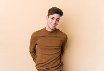 Obraz premium Young caucasian man isolated on beige background happy, smiling and cheerful.