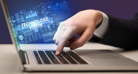 Naklejka na ściany i meble Businessman working on laptop with TECHNOLOGY VISION inscription, cyber technology concept